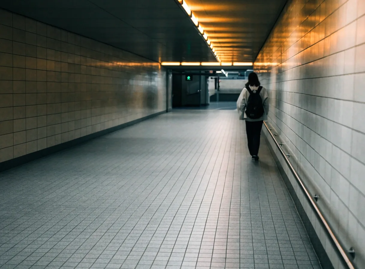 Pasillo de una estación de metro española con una persona caminando hacia el andén