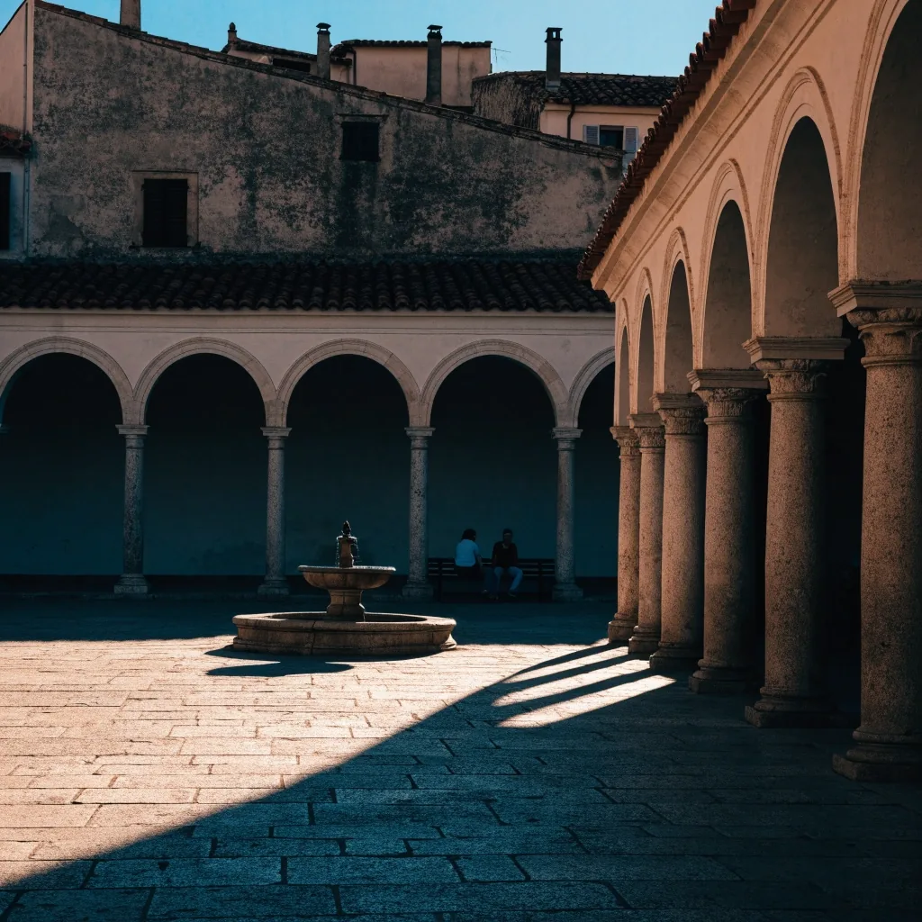 Plaza de un pueblo del interior de España con soportales de piedra y luz cálida de la tarde